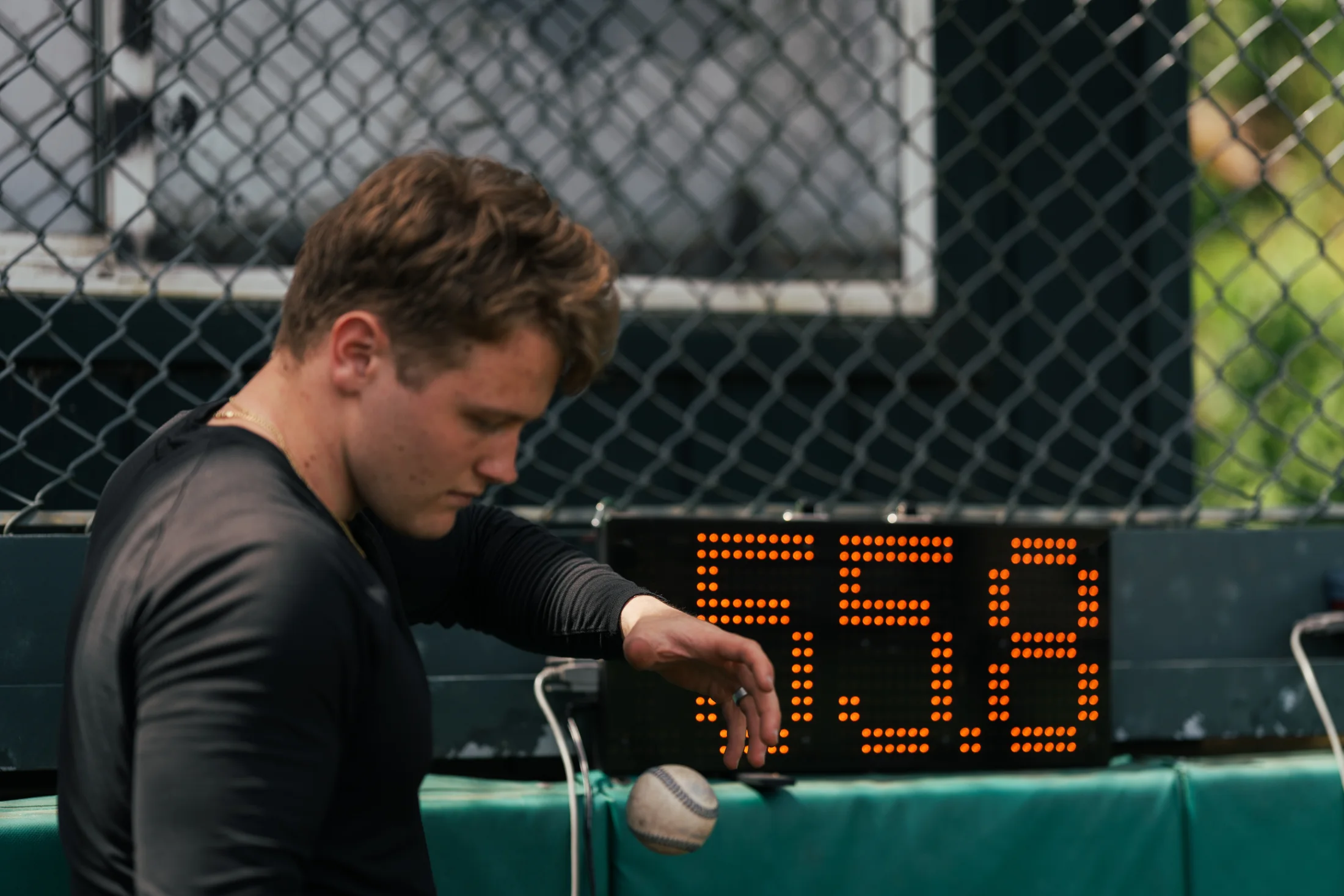 Rubicon athlete holding a baseball near a velocity display